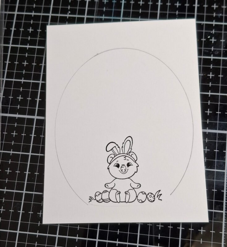 Image of Easter quokka stamped on a white card panel and an egg shape sketched in with pencil